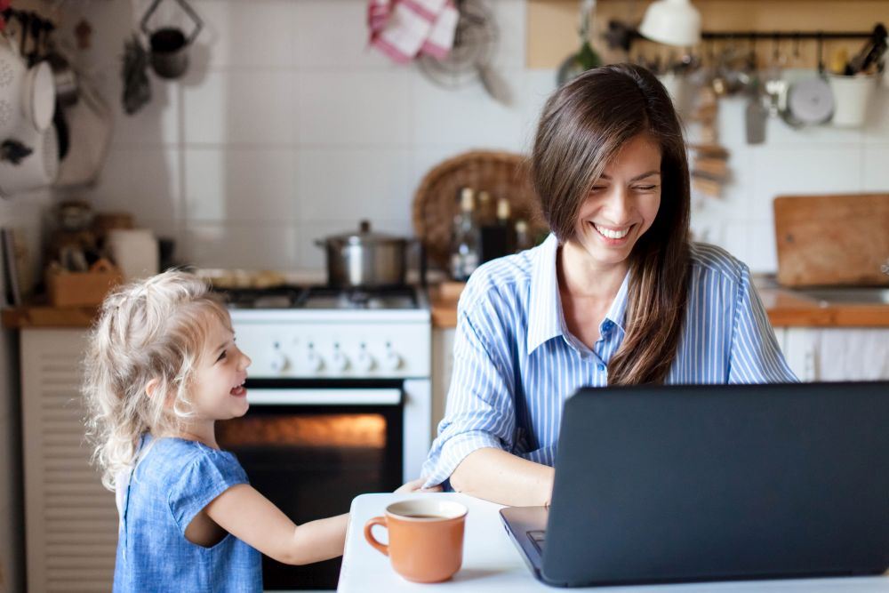 mum on computer with daughter laughing